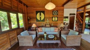a living room with a couch and chairs and a table at BEACH HOUSE WOODY in Laem Sor