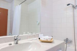 ein Bad mit einem Waschbecken und einem Spiegel in der Unterkunft Wyndham Garden Donaueschingen in Donaueschingen