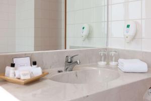 W łazience znajduje się umywalka i lustro. w obiekcie Wyndham Garden Donaueschingen w mieście Donaueschingen