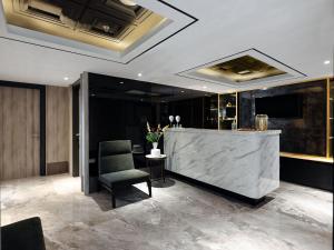 a lobby with a reception desk and a chair at Royal Malioboro by ASTON in Yogyakarta