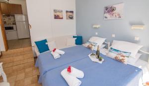 1 dormitorio con cama azul y almohadas blancas en Eleni's Apartments, en Barbati