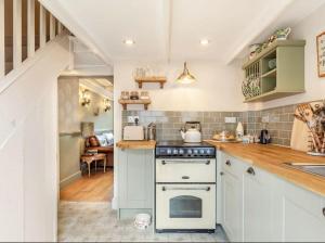 eine Küche mit einem weißen Herd und einer Spüle in der Unterkunft Rosemary Cottage in Bere Alston