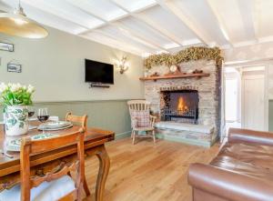 a living room with a fireplace and a table at Rosemary Cottage in Bere Alston