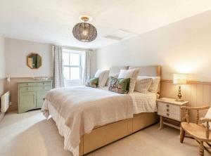 a bedroom with a large bed and a window at Rosemary Cottage in Bere Alston