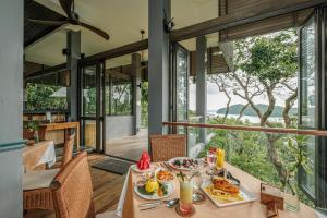a dining room with a table with food on it at Ambong Pool Villas - Private Pool in Pantai Cenang