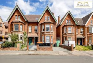 a large brick house on the side of a street at Cosy Modern Escape in 1 or 2BR Apartments with Parking in Bedford