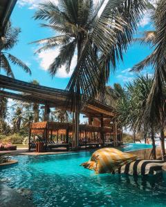 a pool at a resort with palm trees at Hotel Lumi Gili Trawangan in Gili Trawangan
