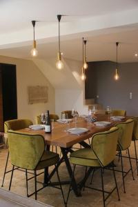 uma sala de jantar com mesa e cadeiras em La Maison Des Vignes ***** em Volnay