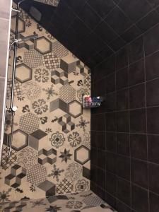 uma casa de banho com um chuveiro em azulejos pretos e brancos. em La Maison Des Vignes ***** em Volnay
