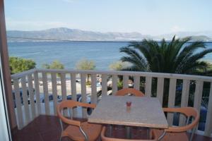 a table and chairs on a balcony with a view of the ocean at Vila Slatine - Beach Apartments in Slatine