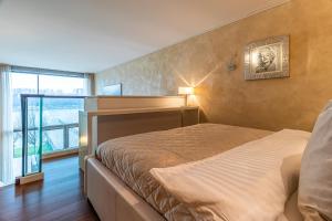 1 dormitorio con cama y ventana grande en Luxury with Danube river view en Petržalka