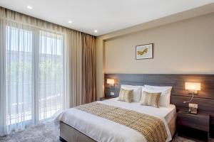 Postel nebo postele na pokoji v ubytování Vinum Hotel