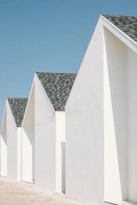 a row of white houses with black roofs at Baan Tah On The Sea in Bang Sare