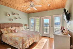 a bedroom with a bed and a ceiling fan at Ruby Redbird Roost in Port Aransas
