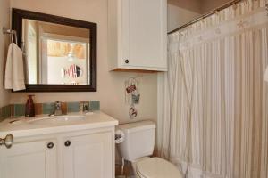 a bathroom with a toilet and a sink and a mirror at Ruby Redbird Roost in Port Aransas +9 photos