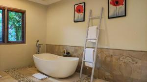 a bathroom with a white bath tub and a ladder at Seminyak Square Hotel And Villas in Seminyak