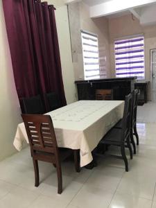 a dining room with a table and chairs and a piano at HJ Homestay in Kuala Terengganu