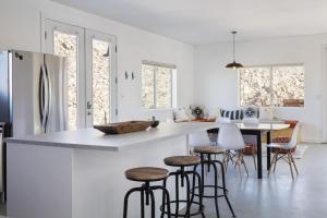 een keuken met een aanrecht en krukken in een kamer bij Rock Box - Modern Adobe Nestled in the Boulders Above Coyote Hol home in Joshua Tree