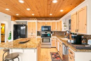 a kitchen with wooden cabinets and granite counter tops at High View Haven - Hot Tub, Fire Pit & BBQ in Joshua Tree! home in Joshua Tree