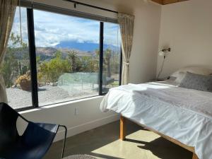 a bedroom with a bed and a large window at Verdin's Nest - Romantic Retreat with Hot Tub Under the Stars! home in Morongo Valley