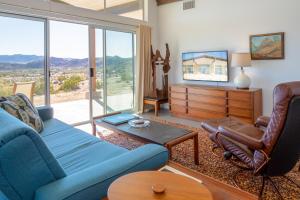 sala de estar con sofá azul y silla en Las Alas del Sol- A Desert Architectural Gem home, en Joshua Tree