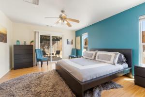 a bedroom with a bed and a blue wall at Colorful Cactus - Hot Tub, BBQ and Fire Pit! home in Joshua Tree