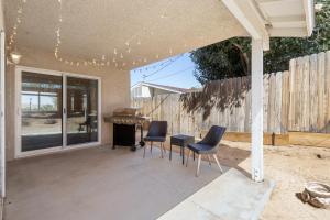 a patio with chairs and a table and a piano at Colorful Cactus - Hot Tub, BBQ and Fire Pit! home in Joshua Tree