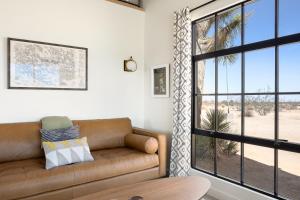 a living room with a couch and a large window at Relax in Style at The Green Jackrabbit - Hot Tub, Record Player home in Sunfair Heights
