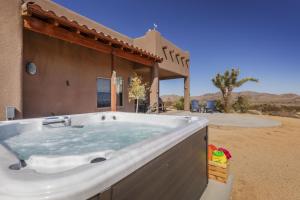 a hot tub in front of a house in the desert at Horizon House - Hot Tub, Fire Pit & BBQ - Adobe in JT home in Joshua Tree