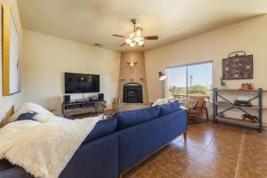 a living room with a blue couch and a tv at Horizon House - Hot Tub, Fire Pit & BBQ - Adobe in JT home in Joshua Tree