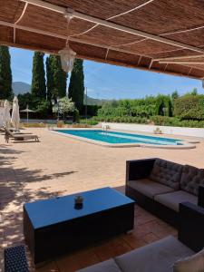 eine Terrasse mit einem Sofa und einem Pool in der Unterkunft Casa de La Campana in Cieza