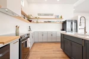 a kitchen with white cabinets and a stainless steel refrigerator at Back Haus - Views, Dark Skies and Fire Pit! home in Joshua Tree +10 photos