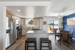 a kitchen with a refrigerator and a table with chairs at Horseshoe House - Hot Tub, BBQ and Fire Pit! home in Joshua Tree