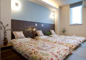 a bedroom with two beds with towels on them at Miidokoro House Hotel in Sapporo