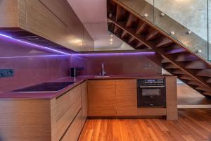cocina con paredes de color púrpura y escalera en Luxury with Danube river view en Petržalka