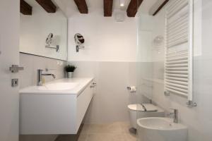 a white bathroom with a toilet and a sink at Residence Modern Art in Venice