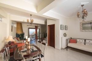 comedor y sala de estar con mesa de comedor en Villa Joanna apartments en Lefkada