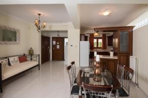 cocina y sala de estar con mesa y sofá en Villa Joanna apartments en Lefkada