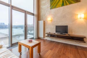 a living room with a tv and large windows at Luxury with Danube river view in Petržalka