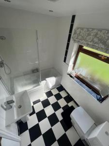 a bathroom with a toilet and a sink and a window at Staycation 3-bedroom home with panoramic views free off road parking in Endon