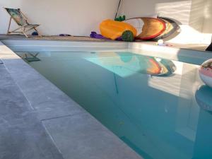 einem Pool mit einer Reflexion eines Kürbis im Wasser in der Unterkunft Appartement lumineux centre Cognac avec terrasse in Cognac