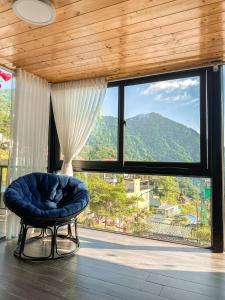a room with a large window with a chair and a view at Bách Xanh House - Cloud Bungalow in Vĩnh Phúc