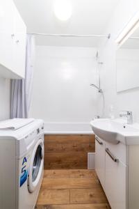 uma casa de banho branca com uma máquina de lavar roupa e um lavatório em Apartament Gersona 4 em Bydgoszcz