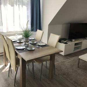 a dining room table with chairs and a television at Ferienwohnung-Ausblick in Vitzdorf