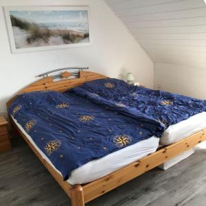 a bedroom with a bed with a blue comforter at Ferienwohnung-Ausblick in Vitzdorf