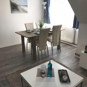 a dining room table with chairs and a bottle of water at Ferienwohnung-Ausblick in Vitzdorf