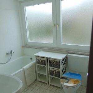 a bathroom with a tub and a toilet and a window at Ferienwohnung-Ausblick in Vitzdorf