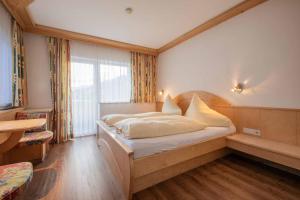 Schlafzimmer mit einem Bett und einem großen Fenster in der Unterkunft Haus Hubertus in Mieders