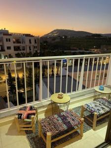 a balcony with two chairs and tables on a building at Paternelle Palace Luxe for 4 or 6 PAX in Agadir