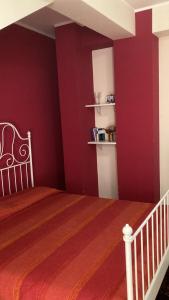 1 dormitorio con paredes rojas y 1 cama en una habitación en Stanza Sole, en Ragalna